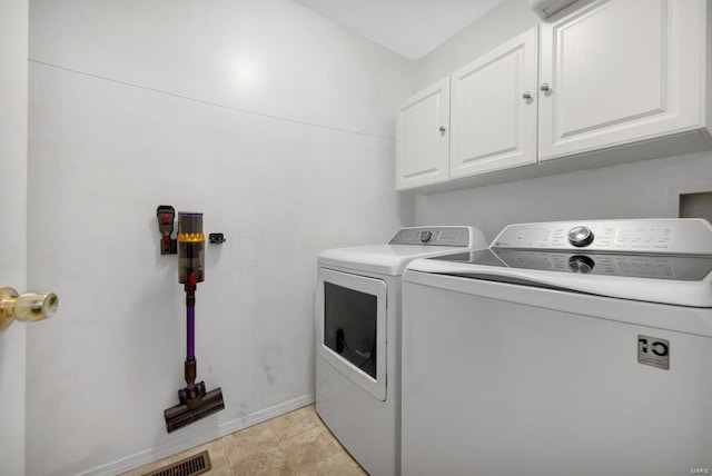 laundry area with separate washer and dryer and cabinets