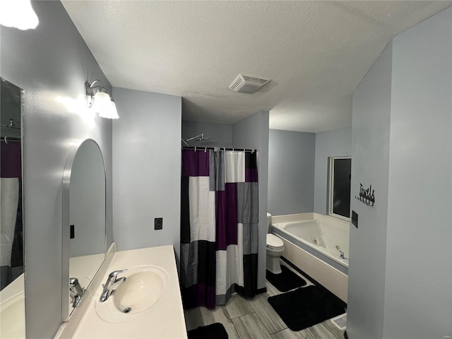 full bathroom featuring a textured ceiling, shower with separate bathtub, vanity, and toilet