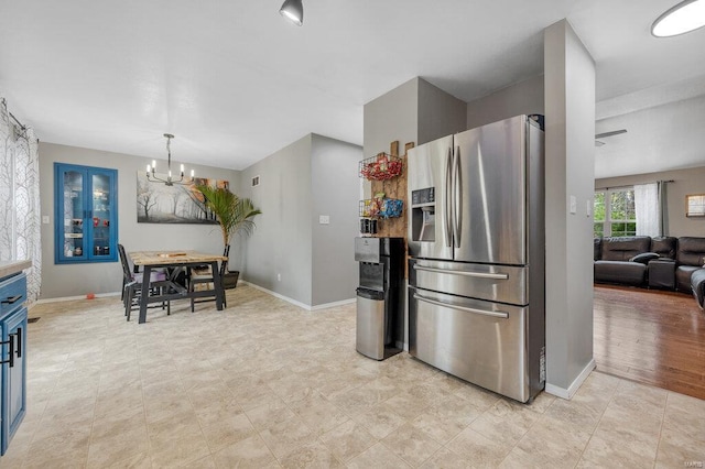 kitchen featuring stainless steel refrigerator with ice dispenser, blue cabinets, and a notable chandelier