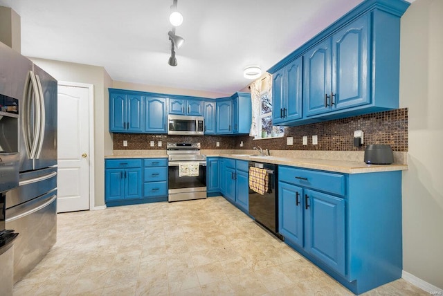 kitchen with sink, stainless steel appliances, blue cabinetry, and decorative backsplash