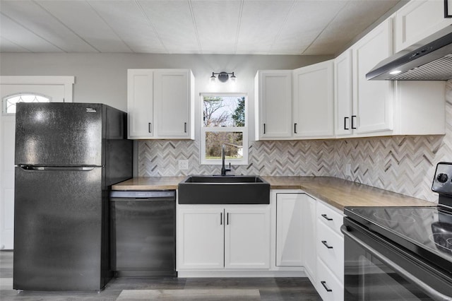 kitchen with sink, black appliances, white cabinets, wall chimney range hood, and dark hardwood / wood-style flooring