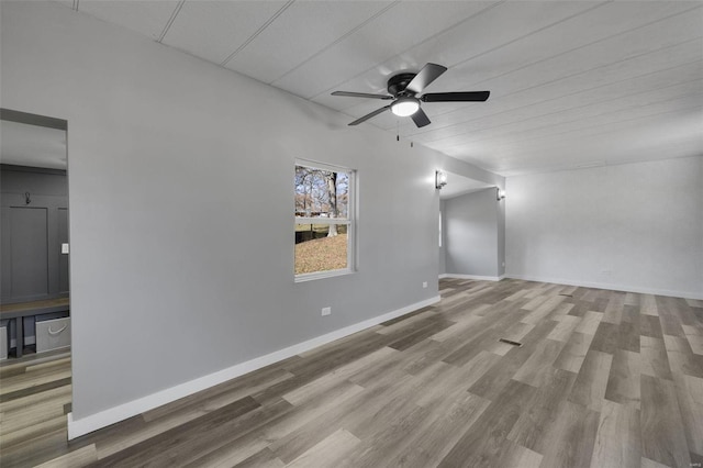 empty room featuring a barn door, light hardwood / wood-style floors, and ceiling fan