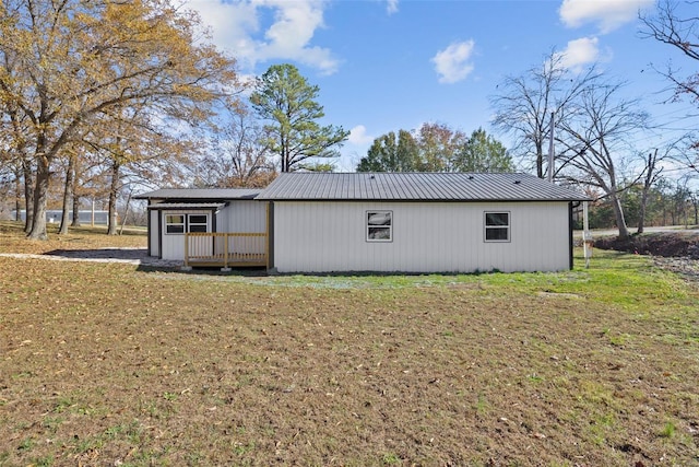 rear view of property featuring a yard and a deck