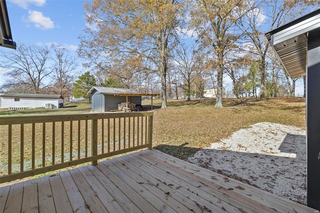 wooden terrace featuring a lawn and a storage unit