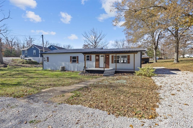 single story home featuring central air condition unit, a porch, and a front lawn