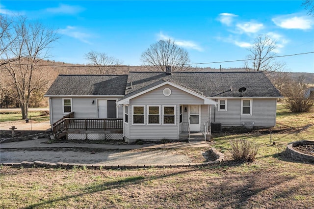 single story home featuring cooling unit, a front lawn, and a deck