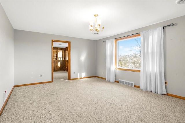 spare room with a notable chandelier and carpet floors