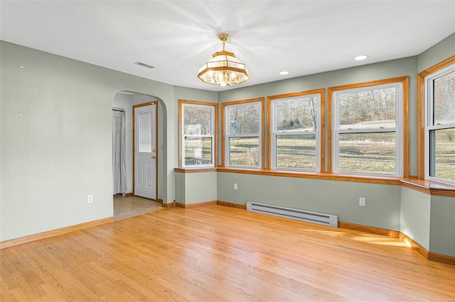 unfurnished room featuring an inviting chandelier, light hardwood / wood-style flooring, and baseboard heating