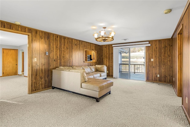 living room with carpet flooring, a notable chandelier, and wood walls