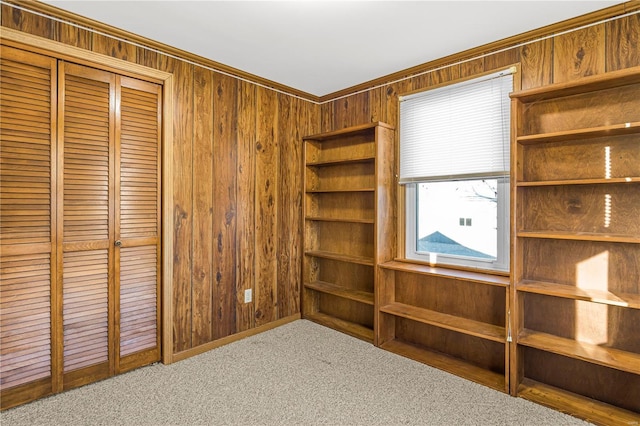 interior space featuring ornamental molding, light carpet, and wooden walls