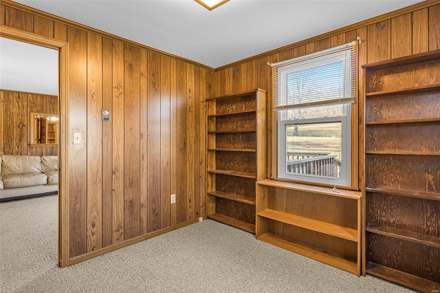 interior space featuring light colored carpet and wooden walls