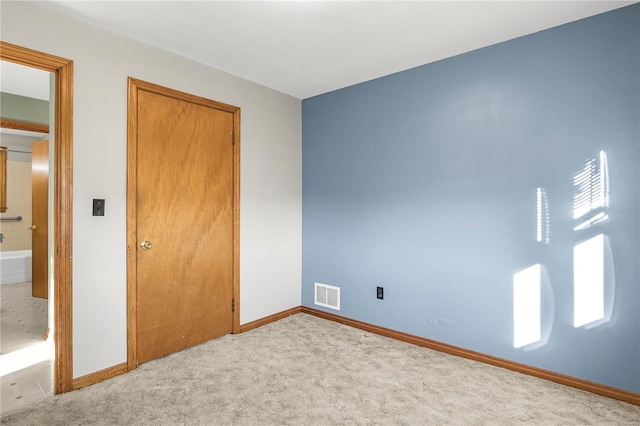 unfurnished bedroom with light carpet and multiple windows