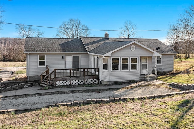 rear view of house with a lawn and a deck