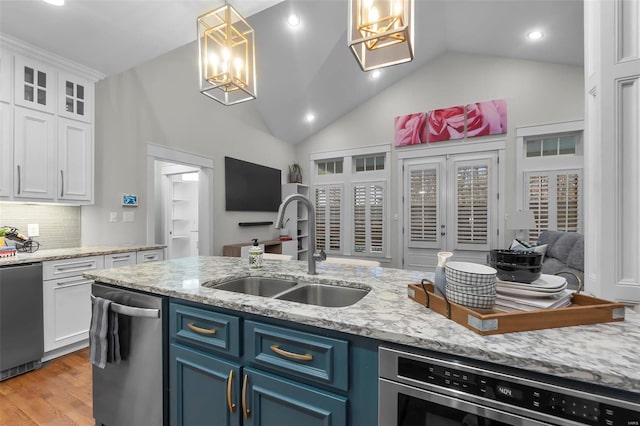 kitchen with blue cabinets, sink, light hardwood / wood-style flooring, decorative light fixtures, and white cabinetry