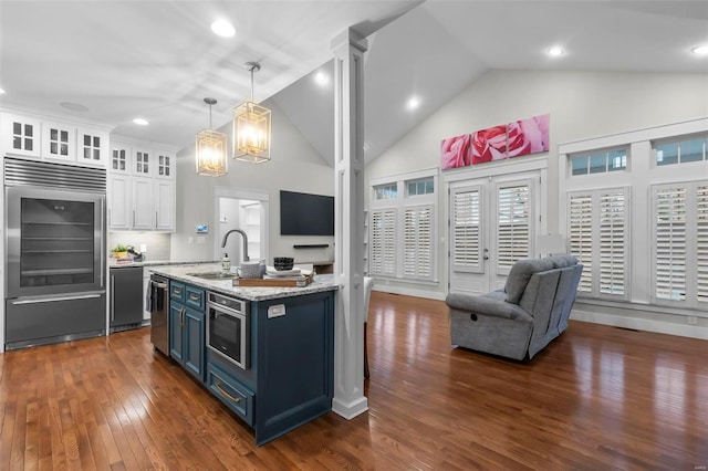 kitchen featuring dark hardwood / wood-style flooring, stainless steel appliances, blue cabinetry, white cabinets, and hanging light fixtures