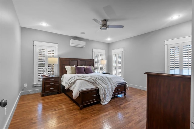 bedroom with ceiling fan, dark wood-type flooring, and a wall mounted AC