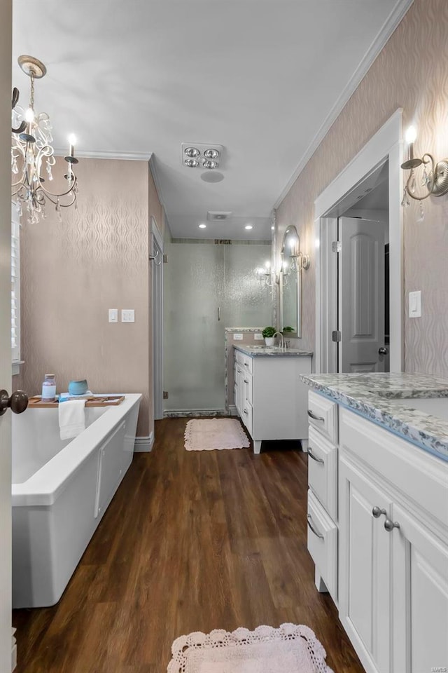 bathroom featuring vanity, an inviting chandelier, separate shower and tub, ornamental molding, and wood-type flooring