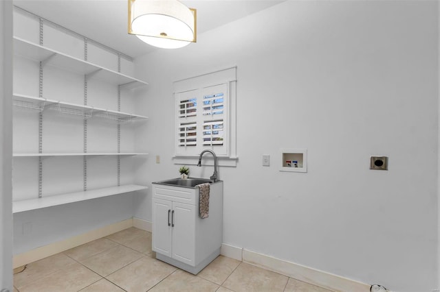 clothes washing area with sink, cabinets, washer hookup, electric dryer hookup, and light tile patterned floors