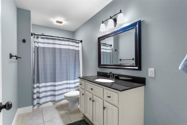 bathroom with tile patterned flooring, vanity, toilet, and walk in shower