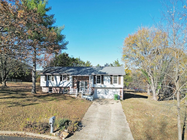 split foyer home with a porch, a front yard, and a garage