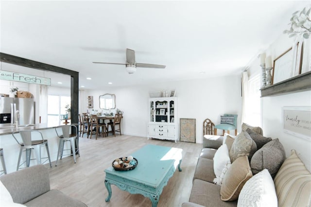 living room with ceiling fan and light hardwood / wood-style flooring