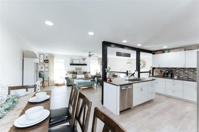 kitchen with white cabinetry, sink, ceiling fan, stainless steel dishwasher, and a kitchen island with sink