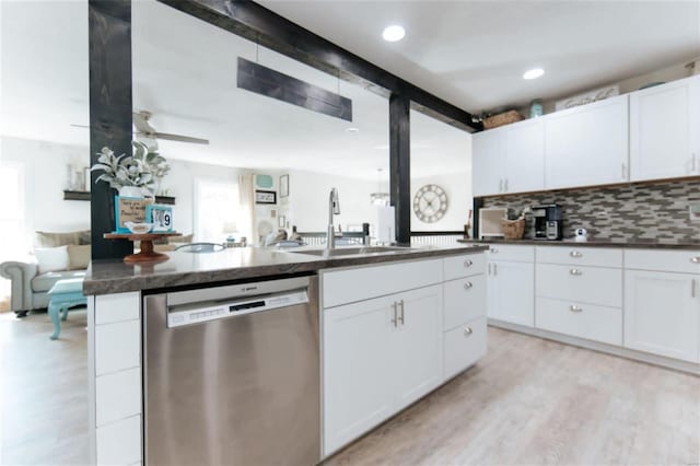 kitchen featuring stainless steel dishwasher, white cabinetry, sink, and a wealth of natural light