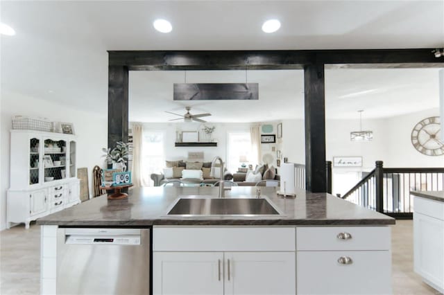 kitchen with ceiling fan, a center island, sink, stainless steel dishwasher, and white cabinets