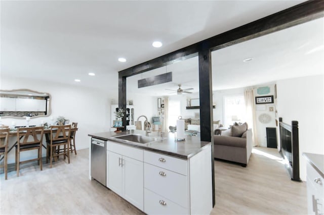 kitchen featuring stainless steel dishwasher, ceiling fan, sink, light hardwood / wood-style flooring, and white cabinetry