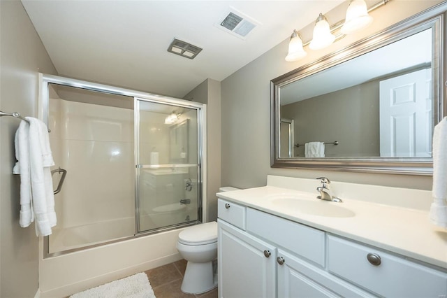 full bathroom with toilet, vanity, bath / shower combo with glass door, and tile patterned floors