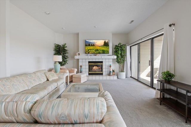 living room featuring carpet floors, a textured ceiling, and a tile fireplace