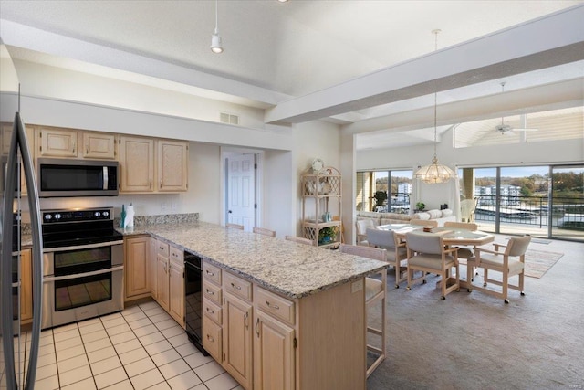 kitchen with kitchen peninsula, light stone counters, appliances with stainless steel finishes, a breakfast bar area, and light colored carpet