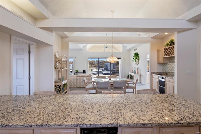 kitchen with pendant lighting, beam ceiling, and light stone countertops