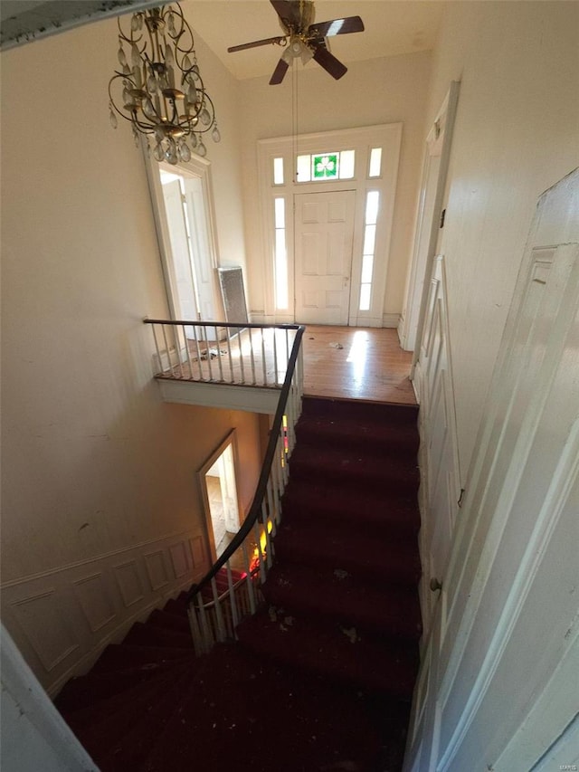 staircase featuring hardwood / wood-style flooring and an inviting chandelier