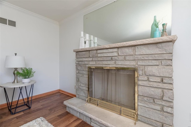 details featuring a stone fireplace, wood-type flooring, and ornamental molding