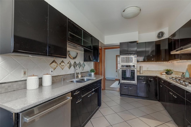 kitchen with light tile patterned flooring, backsplash, stainless steel appliances, and sink