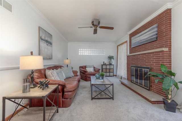 carpeted living room featuring a brick fireplace, ceiling fan, and crown molding