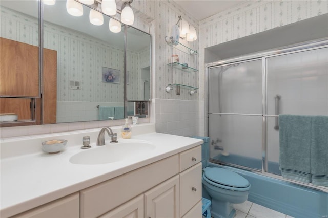 full bathroom featuring shower / bath combination with glass door, tile patterned flooring, vanity, and toilet