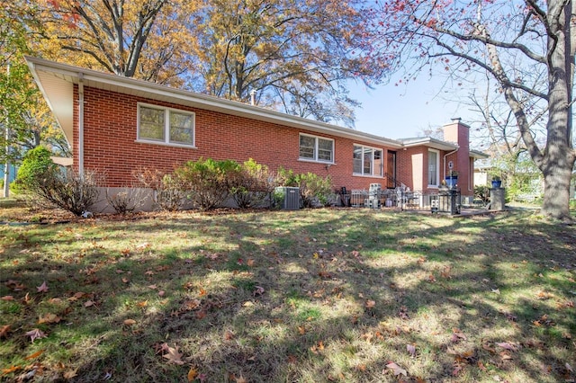 rear view of house with a yard and central air condition unit