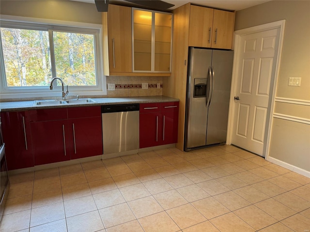 kitchen with decorative backsplash, appliances with stainless steel finishes, sink, and light tile patterned floors