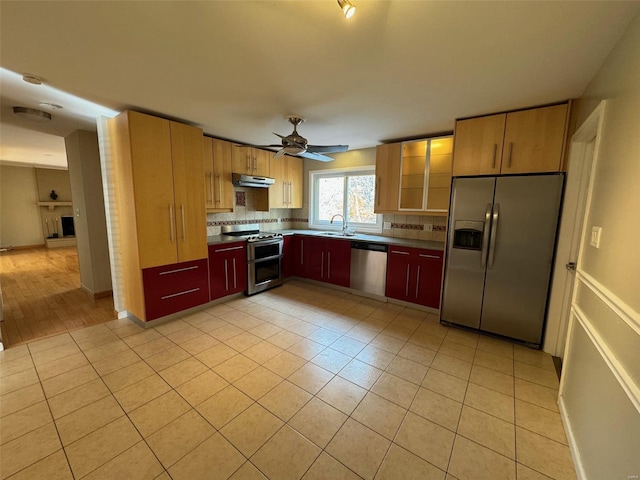 kitchen featuring stainless steel appliances, sink, light tile patterned floors, ceiling fan, and backsplash