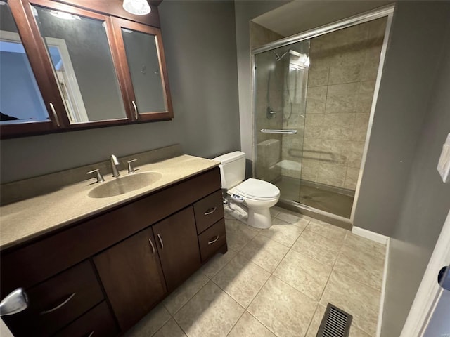 bathroom featuring a shower with door, vanity, tile patterned floors, and toilet