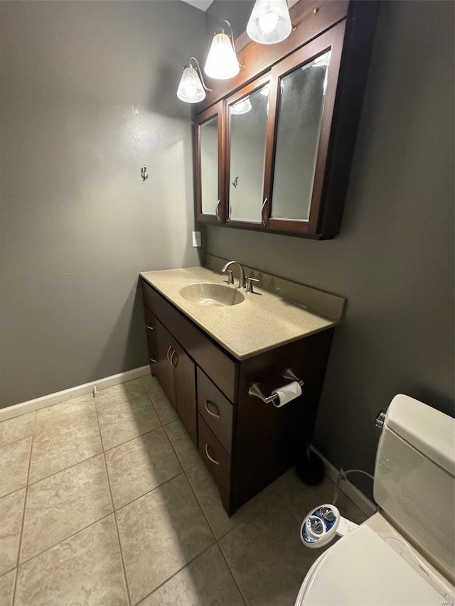 bathroom with vanity, tile patterned flooring, and toilet