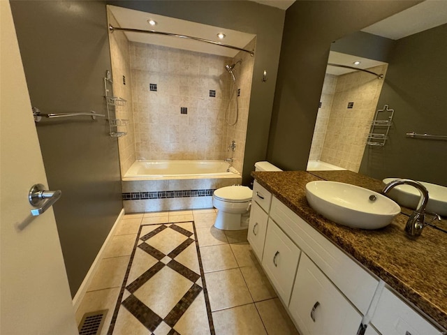 full bathroom featuring toilet, vanity, tiled shower / bath combo, and tile patterned floors