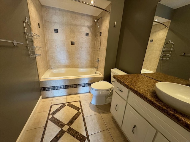 full bathroom with tile patterned flooring, vanity, tiled shower / bath combo, and toilet