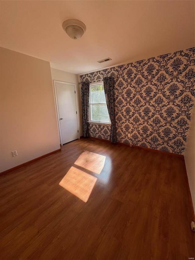 unfurnished room with hardwood / wood-style floors