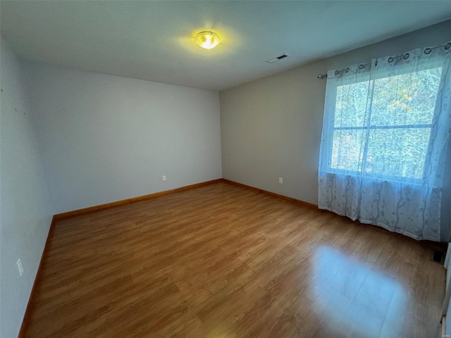 unfurnished room with hardwood / wood-style flooring