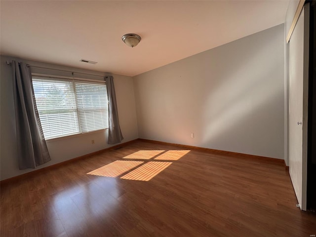 spare room featuring dark wood-type flooring