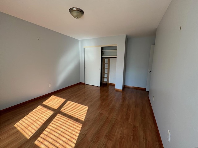 unfurnished bedroom with dark hardwood / wood-style floors and a closet