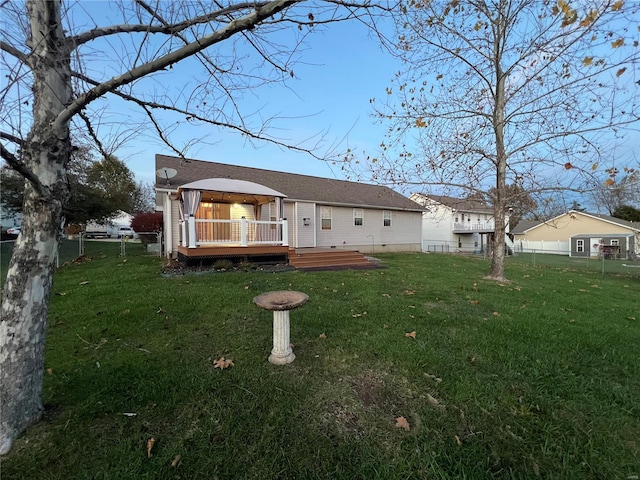 rear view of house featuring a deck and a yard